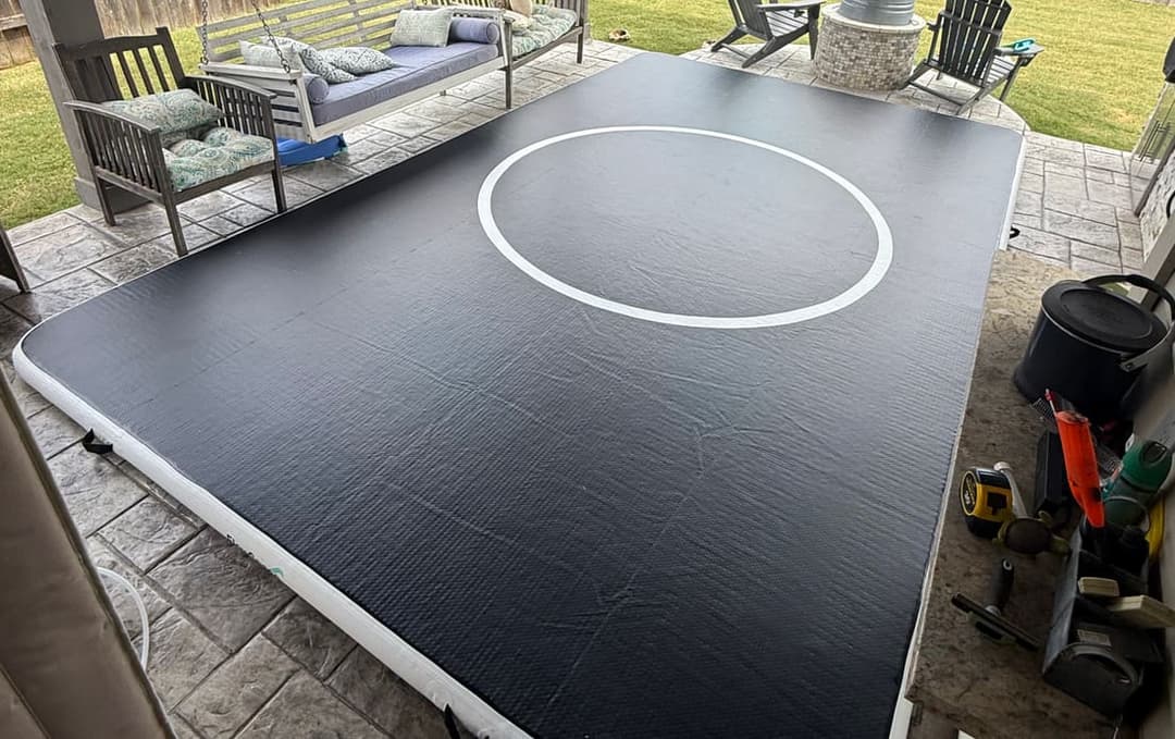 A 10 by 16 Pro FlowMat filling a covered back patio, with a garden swing and lawn behind it
