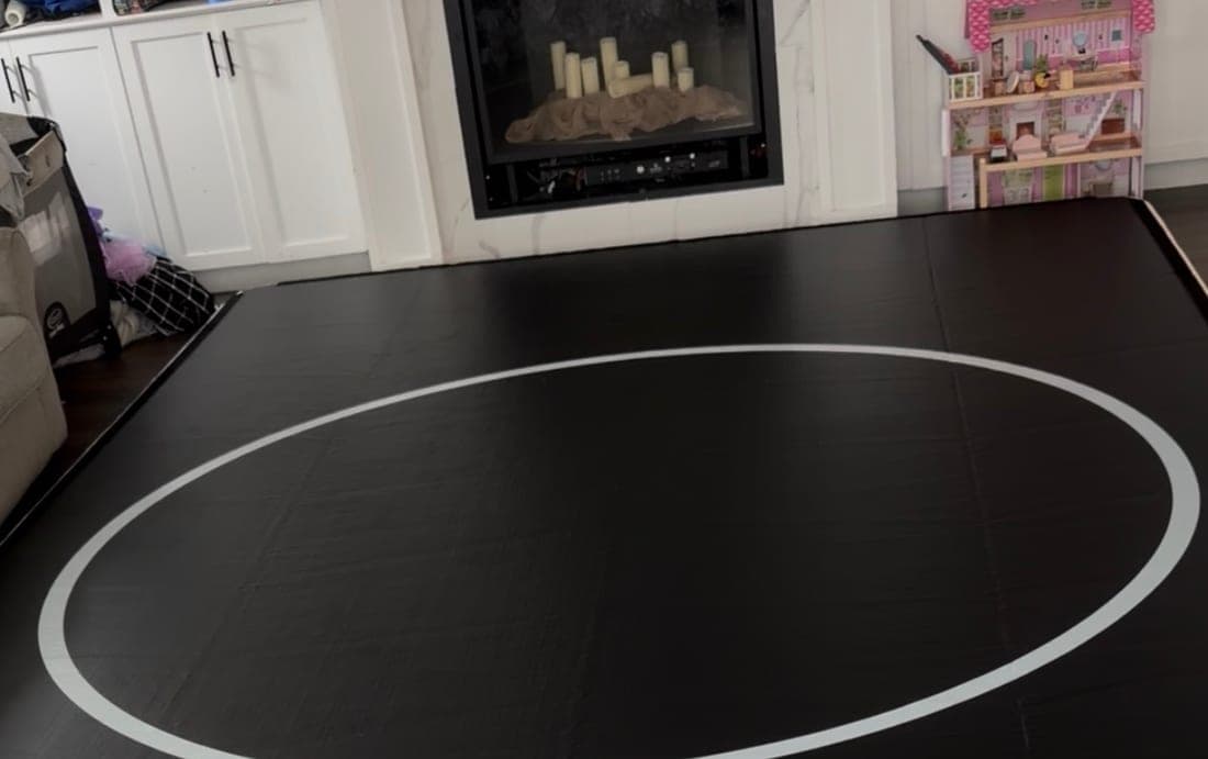 A 10 by 16 Pro FlowMat covering the floor of a family living room, in front of a fireplace and beside a sofa
