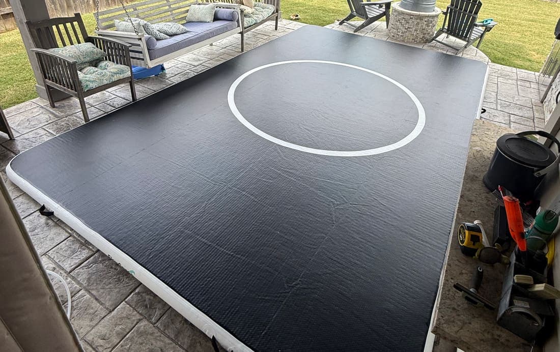 A 10 by 16 Pro FlowMat filling a covered back patio, with a garden swing and lawn behind it